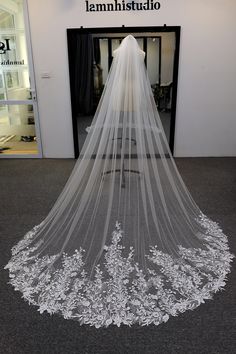 a white wedding veil is on display in front of a storefront with an open door