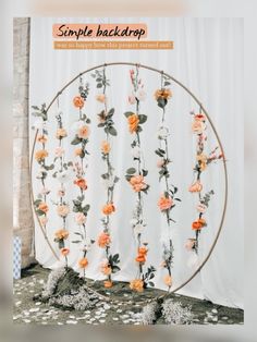 an arrangement of flowers is arranged in a circle on the floor next to a white curtain