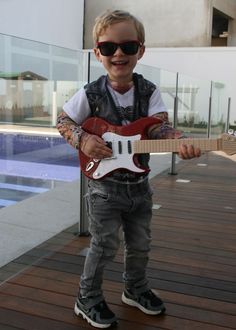 a little boy that is holding a guitar