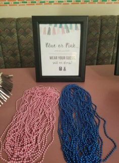 some beads are sitting on a table next to a framed sign and other items for sale