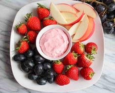 a white plate topped with fruit and dip