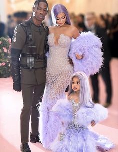 the couple are dressed up as they pose for a photo with their daughter, who is wearing