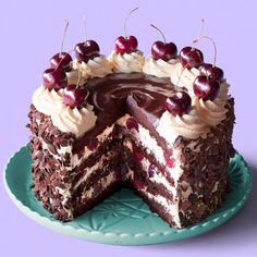 a chocolate cake with white frosting and cherries