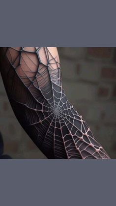 a person with a spider web tattoo on their arm and leg, showing it's intricate