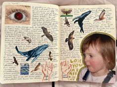 an open book with pictures of birds and animals on it, in front of a child's face