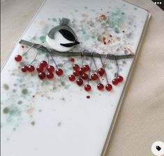 a white plate with red berries and a bird on it