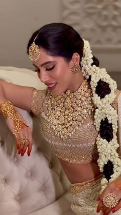 a woman in a bridal outfit sitting on a couch