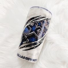 a blue and white tumbler sitting on top of a fur covered floor