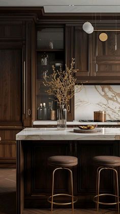 a kitchen with wooden cabinets and marble counter tops, two stools at the island