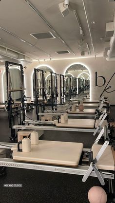 a gym with rows of exercise equipment and mirrors