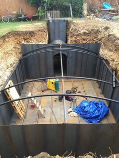 a large metal boat sitting in the middle of a yard next to a pile of dirt