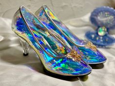 a pair of high heeled shoes with holographics on them sitting on a white cloth