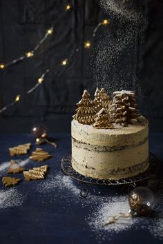 a cake with frosting and pine cones on top, sprinkled with icing