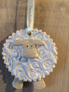 a ceramic sheep ornament hanging on a wall