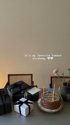 a birthday cake sitting on top of a table next to boxes with candles in them