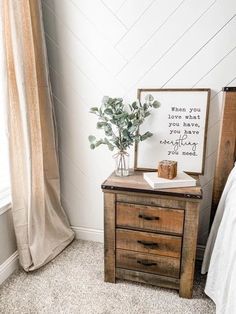 a bedroom with a bed, nightstand and plant on top of the dresser next to it