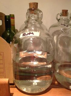 two large glass bottles sitting on top of a wooden shelf