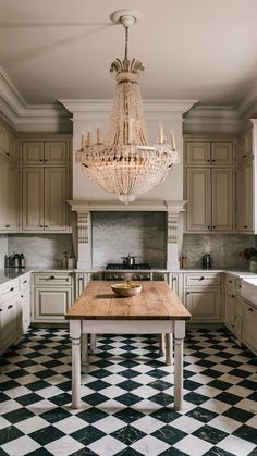 a chandelier hanging from the ceiling in a kitchen with black and white checkered flooring