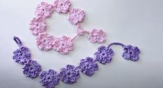 two crocheted necklaces are laying on the table next to each other and one is pink and purple