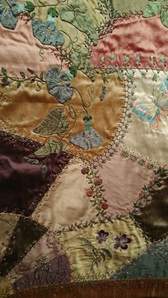 an old quilt with flowers and leaves on it