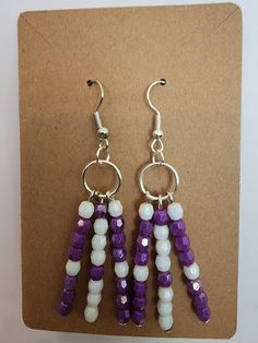 These charming multi-strand dangle earrings show off your affinity for all things purple! Purple Tassel Drop Earrings With Dangling Beads, Purple Drop Chandelier Earrings As Gift, Purple Drop Earrings With Dangling Beads, Purple Dangling Beads Chandelier Earrings, Lavender Adjustable Dangle Beaded Earrings, Lavender Beaded Dangle Earrings, Purple Dangle Earrings With Beads, Adjustable Purple Chandelier Drop Earrings, Purple Chandelier Earrings With Ear Wire As A Gift