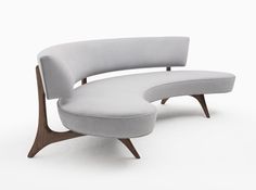 the curved chair and ottoman are both made out of wood, with grey fabric upholstered on each side