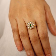 Introducing the Neema Daisy Green Ring from Yamoona: a fusion of heritage-style Indian craftsmanship and modern elegance. Crafted from 925 silver with a lustrous gold plating, this exquisite finger ring features an intricate floral design with a vivid green center stone. Its versatile and timeless appeal makes it a must-have accessory, suitable for Indian traditional attire occasions. The heritage-inspired craftsmanship, proudly brought to you by Yamoona, showcases intricate Indian artistry while the gold finish adds a touch of luxury. Whether you're treating yourself or looking for a meaningful gift, the Neema Daisy Green Ring is a symbol of beauty, grace, and cultural richness that will adorn your finger with timeless sophistication. Gifting: This choker set comes in a beautiful Yamoona Elegant Gold Flower Ring For Festive Occasion, Round Tilla Rings For Wedding, Flower Shaped Wedding Jewelry, Festive Flower-shaped Wedding Jewelry, Festive Flower Wedding Jewelry, Elegant Rings For Festive Celebrations, Elegant Festive Rings For Celebration, Elegant Green Rings For Festive Occasions, Elegant Festive Rings For Anniversary