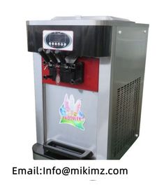 an ice cream machine sitting on top of a white table next to a red and black box