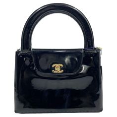 Own a Parisian dream: Vintage Chanel Kelly in black patent leather. This iconic bag exudes timeless elegance, with high-shine patent reflecting years of love (and light wear). 24k gold plated hardware adds a touch of Parisian luxury, while subtle age marks whisper tales of glamorous adventures. The Chanel Kelly reissued in 2023 is the IT bag of the year, and this vintage model lets you own the style with a steal of a price. Carry it by hand or on your arm to elevate any outfit and embrace the timeless beauty of Chanel. Vintage Chanel Kelly Black patent leather 24k gold plated hardware Width: 25cm Height: 17cm Vintage Kelly Bag, Chanel Kelly, Parisian Luxury, Vintage Chanel Bag, Chanel Top, Vintage Kelly, Chanel Chanel, Kelly Bag, Chanel Vintage