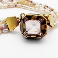 "Retro multi-strand two tone Fresh Water Pearl necklace, decorated with 14 K (.585) yellow gold chamfered square form pendant, featuring pale Amethyst centerpiece and Onyx borders, accented with Diamonds. Necklace also has yellow gold clasp and tiny bead accents. This majestic necklace is 17 7/8\" long, the pendant is 3/4\" square, the stone measures 12 mm x 13mm. EA461." Luxury Rectangular Jewelry With Gemstone Accents, Fine Jewelry With Gemstone Accents Rectangular Shape, Fine Jewelry With Rectangular Gemstone Accents, Exquisite Rectangular Formal Jewelry, Square Gemstone Jewelry For Formal Occasions, Formal Square Gemstone Jewelry, Elegant Multi-stone Rectangular Jewelry, Square Yellow Gold Jewelry With Gemstone, Elegant Rectangular Multi-stone Jewelry