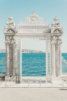 an ornate white archway overlooking the ocean