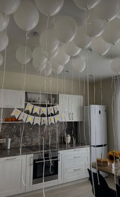 white balloons floating from the ceiling in a kitchen