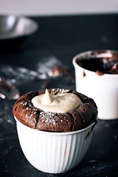 two cups filled with chocolate pudding on top of a table