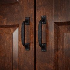 two wooden doors with metal handles on them