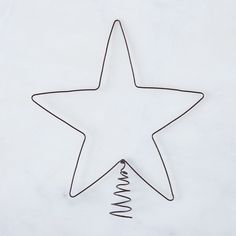 a wire star with a spiral on it sitting next to a white paper wallpaper