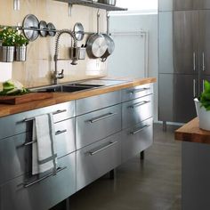 a kitchen with stainless steel cabinets and wooden counter tops