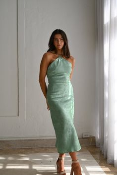 a woman in a green dress posing for the camera