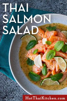 thai salmon salad in a white bowl with limes and mint garnish on the side