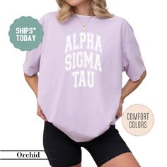 a woman wearing shorts and a purple shirt with the words, alpha sigma tau