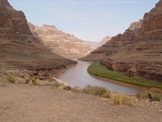 there is a river in the middle of the desert with mountains in the back ground