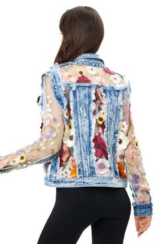 a woman is wearing a jean jacket with flowers on it and black leggings