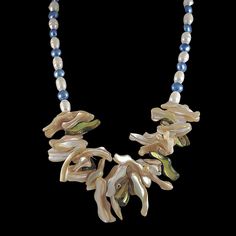 Wearable Art As Unique As The One Who Wears It!🦋This stunning one-of-a-kind mother of pearl necklace is a must have! A striking statement piece which will add the "wow factor" to any outfit!Natural beige and green frangia mother-of-pearl beads add pizazz to this flower petal bib. An elegant strand of aquamarine blue and white cultured freshwater pearls tapers off around the neck with a sterling silver toggle closure. GemArt: The Aquamarine Galaxy Statement Necklace🦋 💎 19-inch Statement Neckla Unique Pearl White Necklace For Gift, Unique Pearl White Necklace As Gift, Handmade Blue Mother Of Pearl Jewelry, Artisan Pearl Necklace Gift, Unique Mother Of Pearl Necklace For Gift, Handmade Pearl White Mother Of Pearl Necklace, Handmade Mother Of Pearl Necklace For Gift, Gift Necklaces With High Luster Mother Of Pearl, White Mother Of Pearl Necklace For Mother's Day