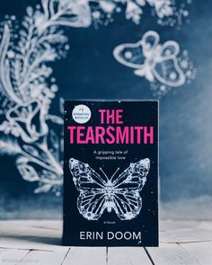 the cover of the book, the tearsmith by fern domm on a wooden table