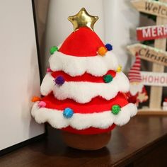 a red and white christmas hat sitting on top of a wooden table next to a sign