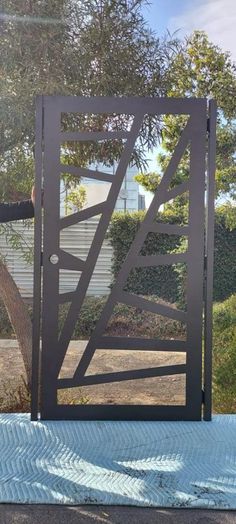 a man is standing in front of a gate that has been made out of metal