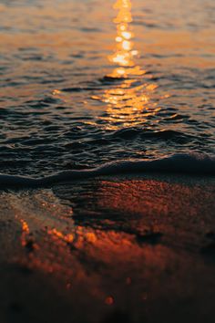 the sun is setting over the water at the beach