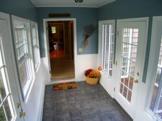 an empty room with blue walls and white trim on the doors, windows and carpet