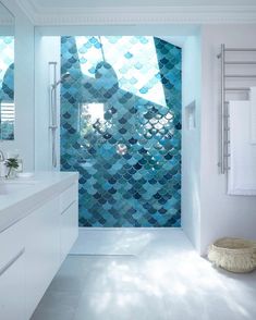 a bathroom with blue tiles on the shower wall