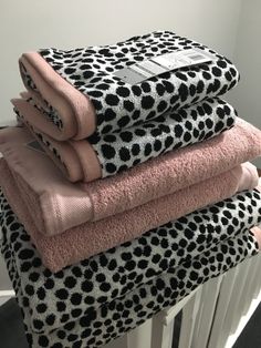 three towels stacked on top of each other in front of a white radiator