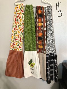 four different colored kitchen towels hanging on a rack